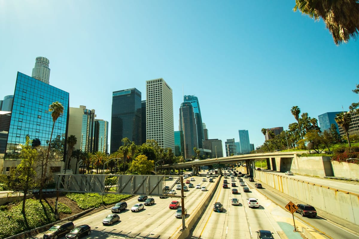 Downtown towers above a multi-lane freeway under a clear sky