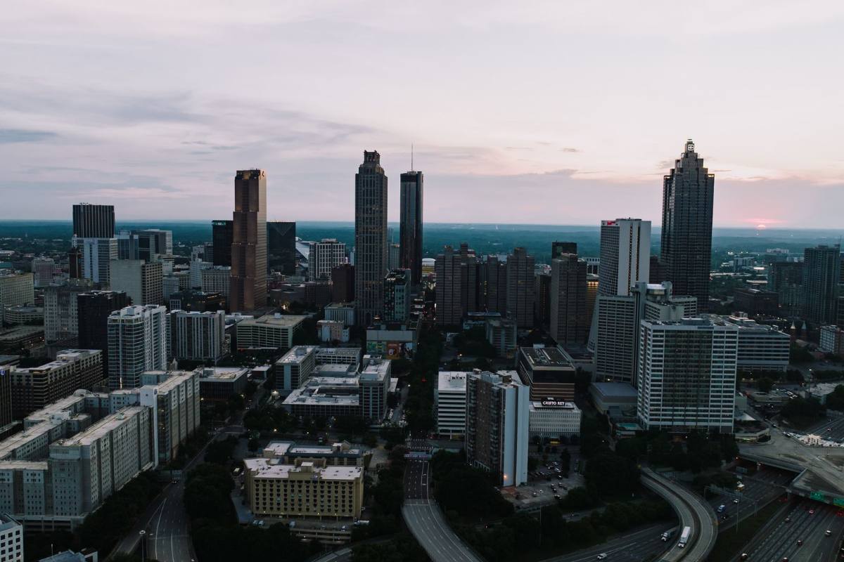 A downtown skyline of glass towers seen from above at dusk