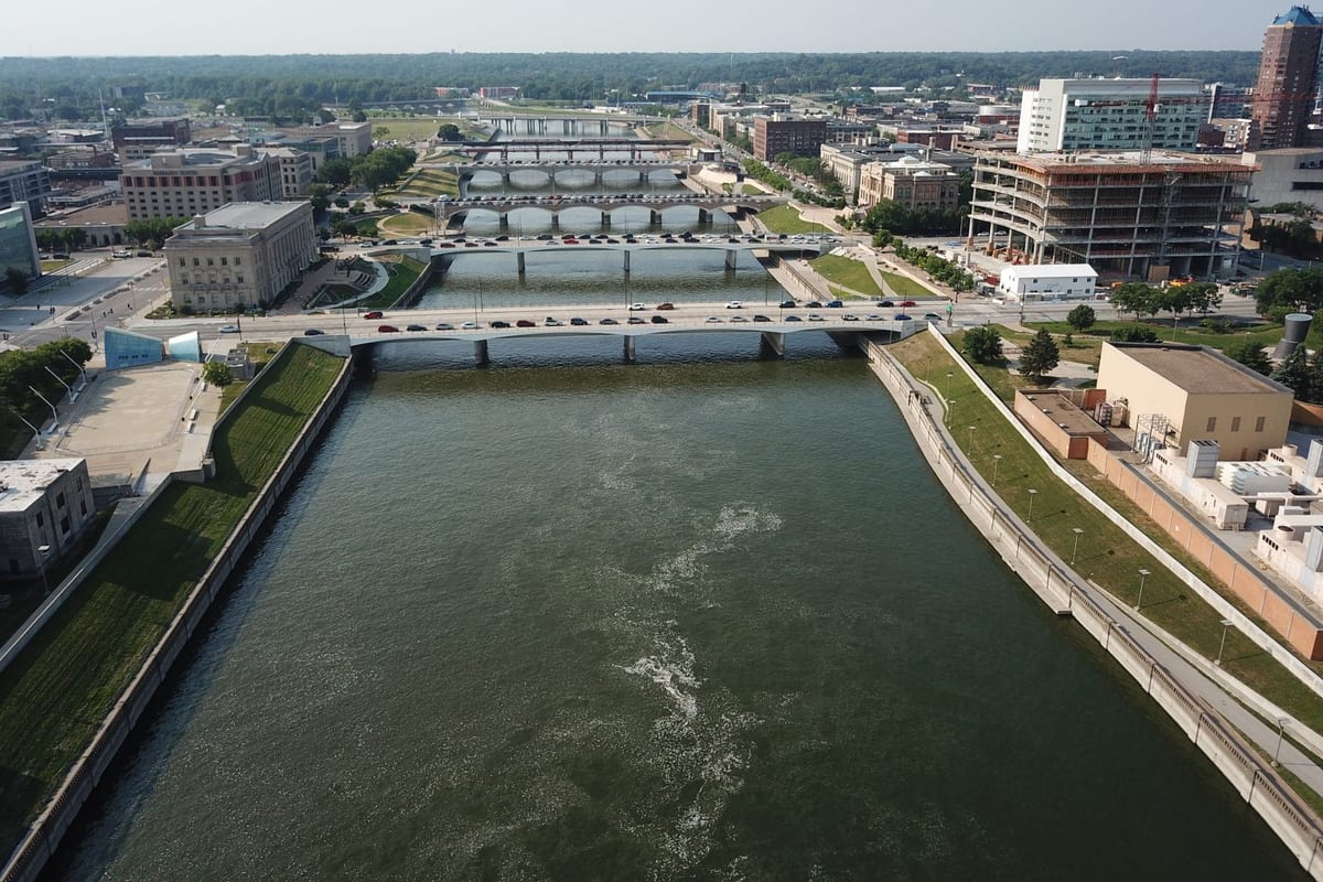 A river running between bridges through a low downtown, seen from the air on a clear day