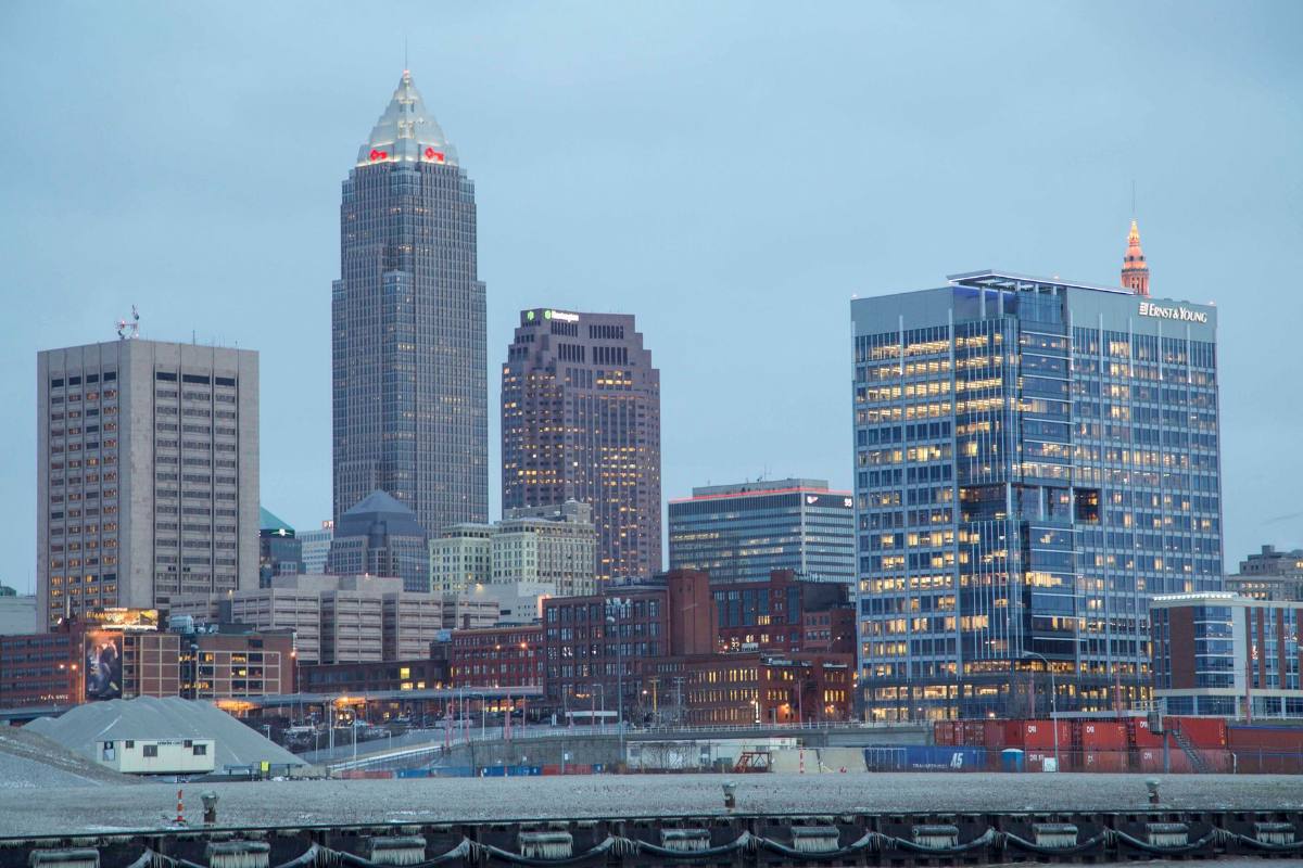 A downtown skyline of lit towers at dusk