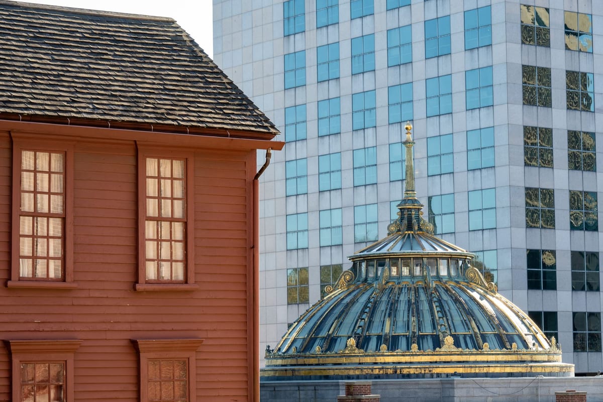 Colonial brick houses standing directly below modern office towers