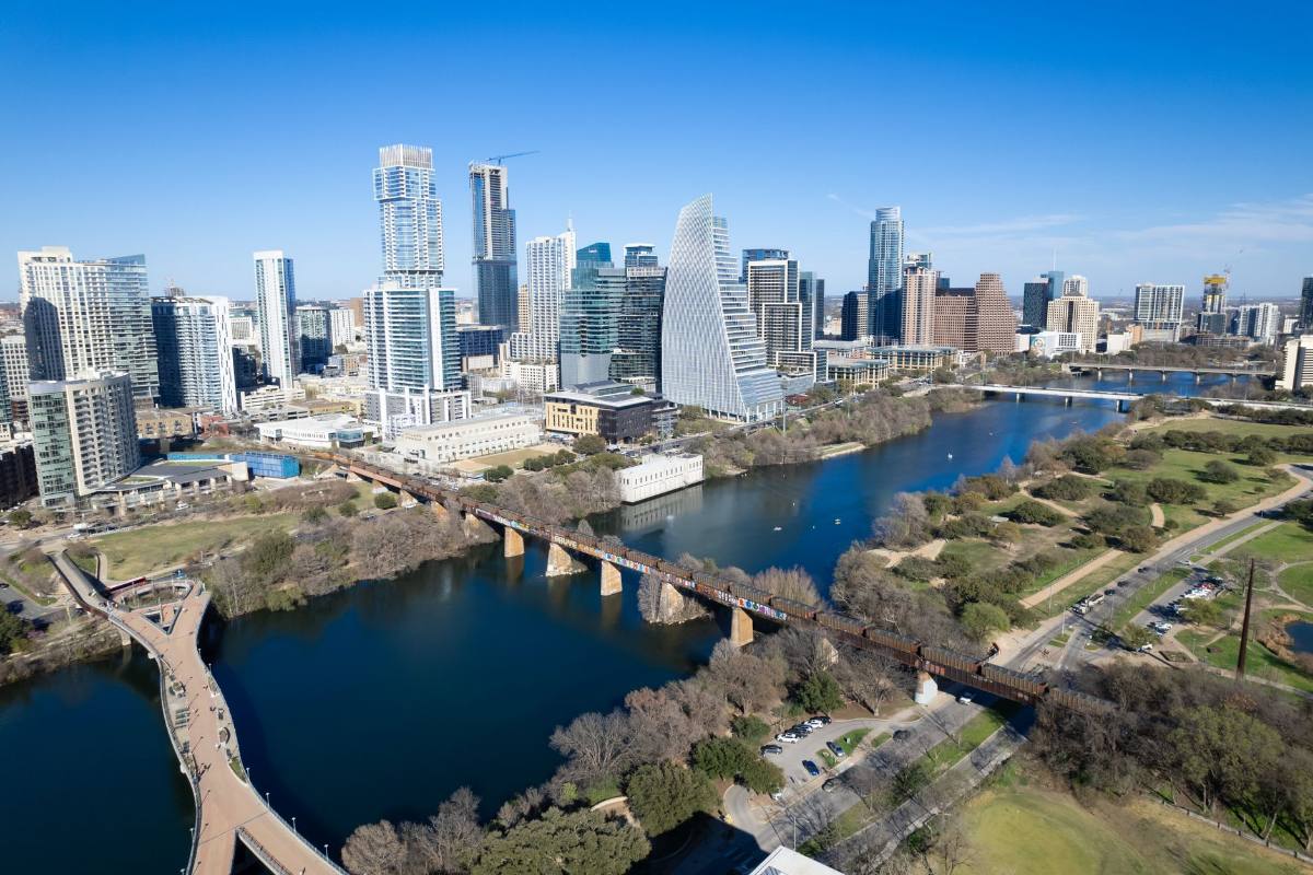 A river curving past a downtown of glass towers, seen from the air
